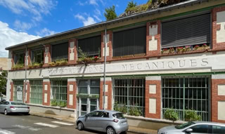 Façade de la grunböx où se trouve l'agence à Vienne. C'est une ancienne industriel où l'on peut toujours lire "constructions mécaniques" au milieu des modénatures en brique.