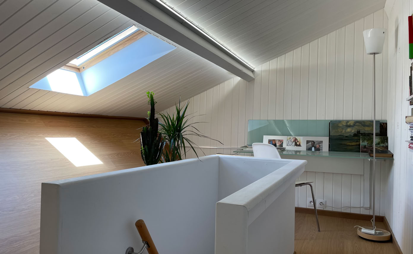 Cage d'escalier et bureau lumineux aménagé sous toiture dans la tiny house urbaine à Vaulx-en-Velin.