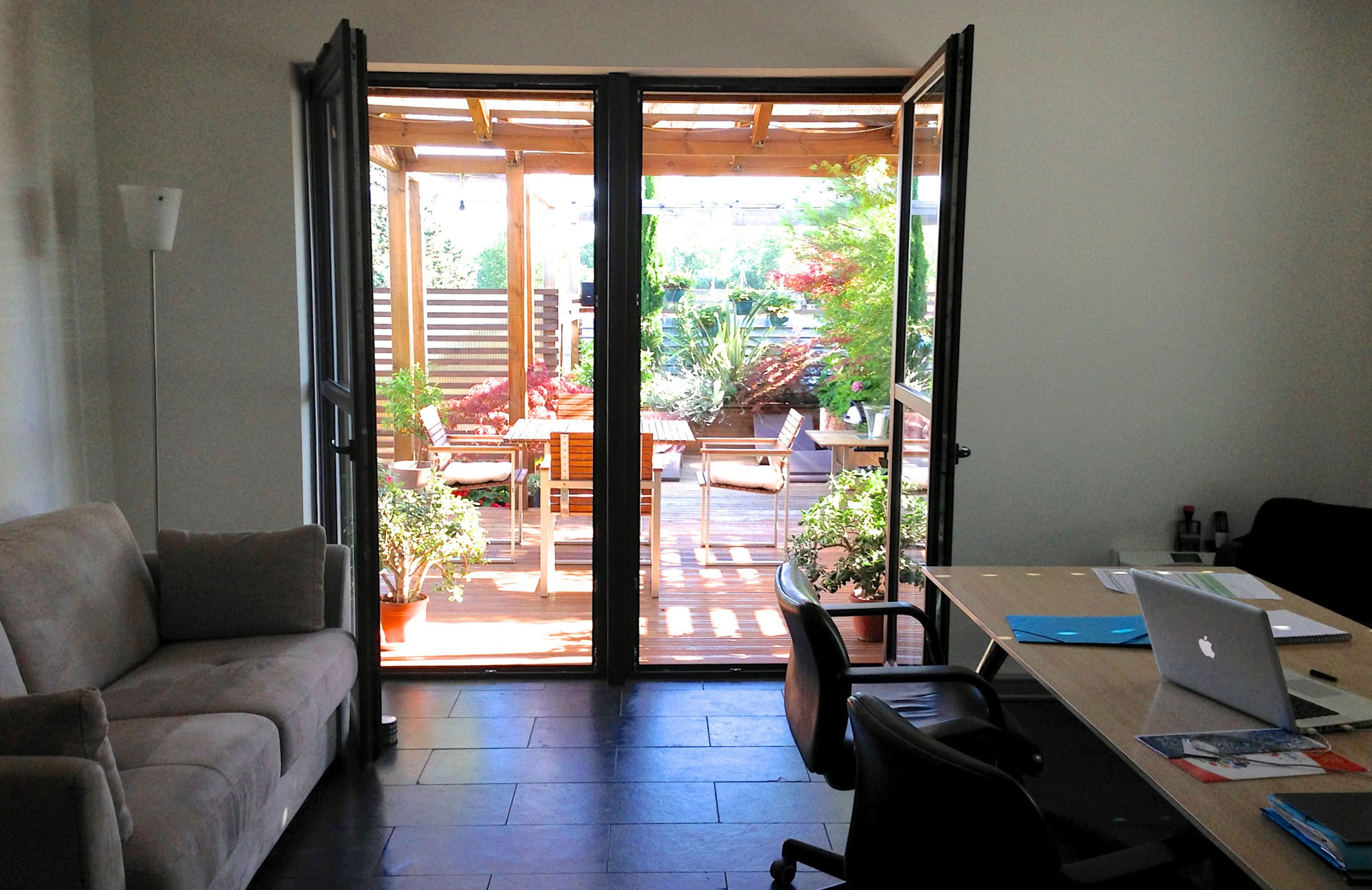 Photo de bureaux ouverts sur une terrasse bois végétalisée dans un des projets réalisé par l'agence.